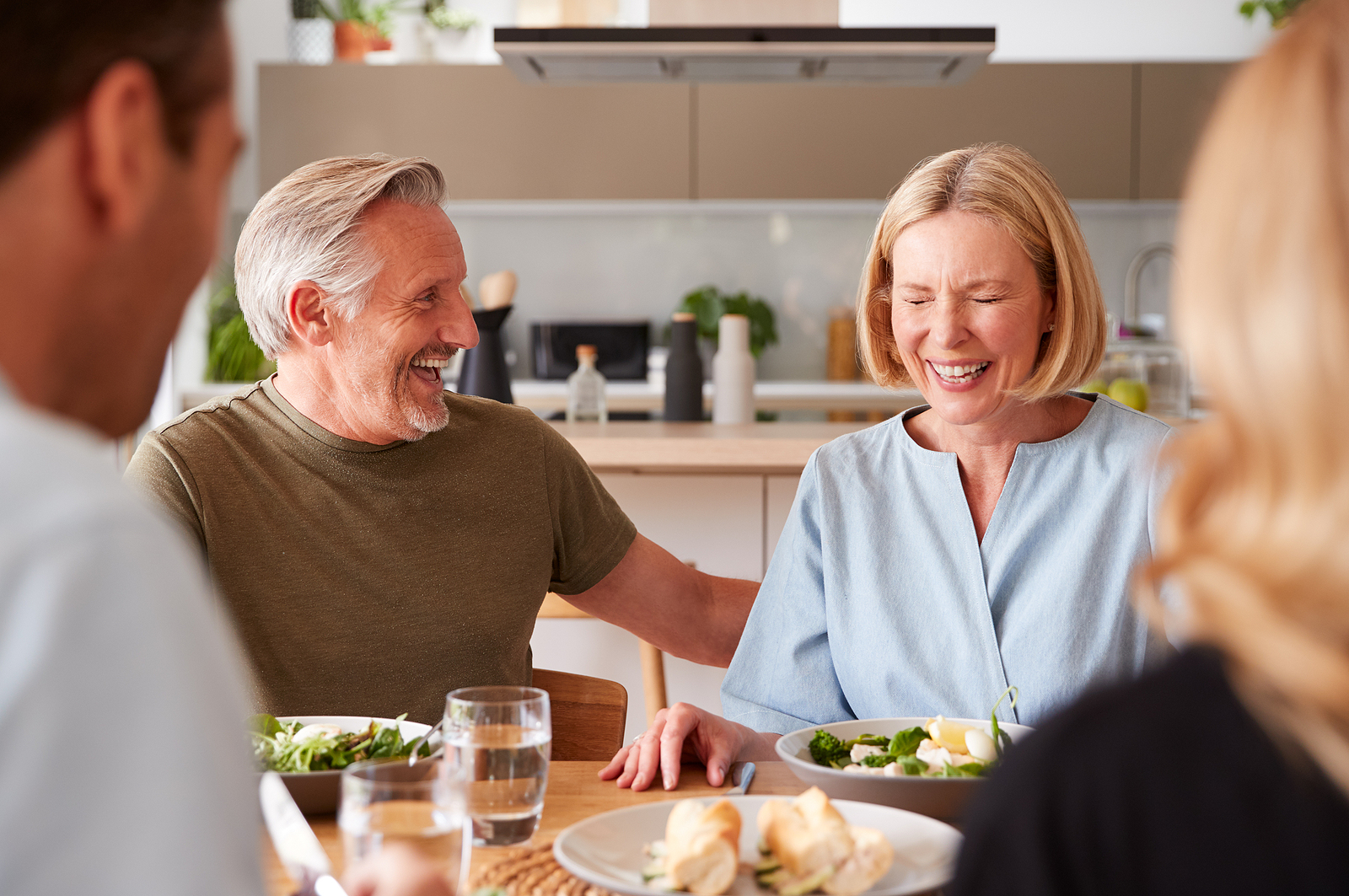 Older couple laughing together at a meal