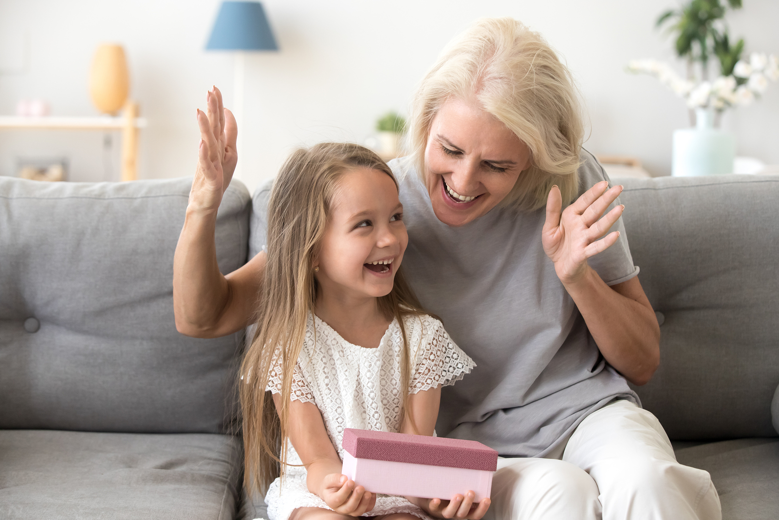 Grandmother and granddaughter laughing together on a couch
